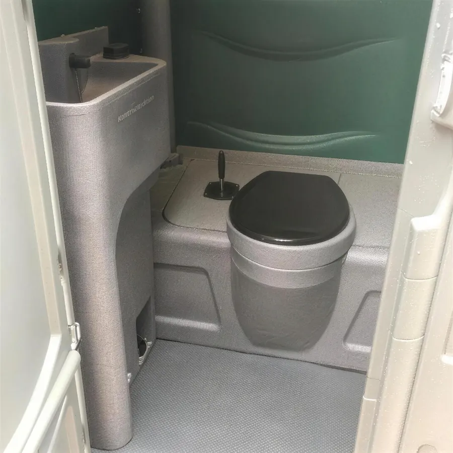 Inside one of our portable toilets, with a hand basin beside the seat